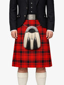 Person wearing a red tartan kilt with a black jacket and white knee-high socks on a white background