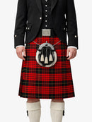 Person wearing a red tartan kilt with a black jacket on a white background