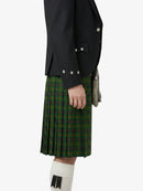 Person wearing a black jacket and green plaid kilt on a white background