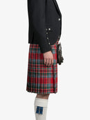Person wearing a black jacket and red plaid kilt on a white background