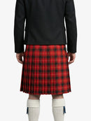 Person wearing a red plaid kilt with a black jacket on a white background