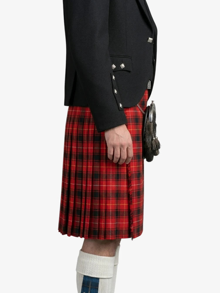 Person wearing a black jacket and red plaid kilt on a white background