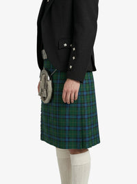 Person wearing a black blazer and green plaid kilt on a white background