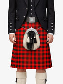 Person wearing a traditional Scottish kilt with a tartan pattern on a white background