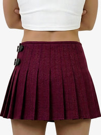 Maroon pleated skirt with black buttons worn by a person on a white background