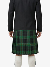 Person wearing a black coat and green plaid kilt on a white background