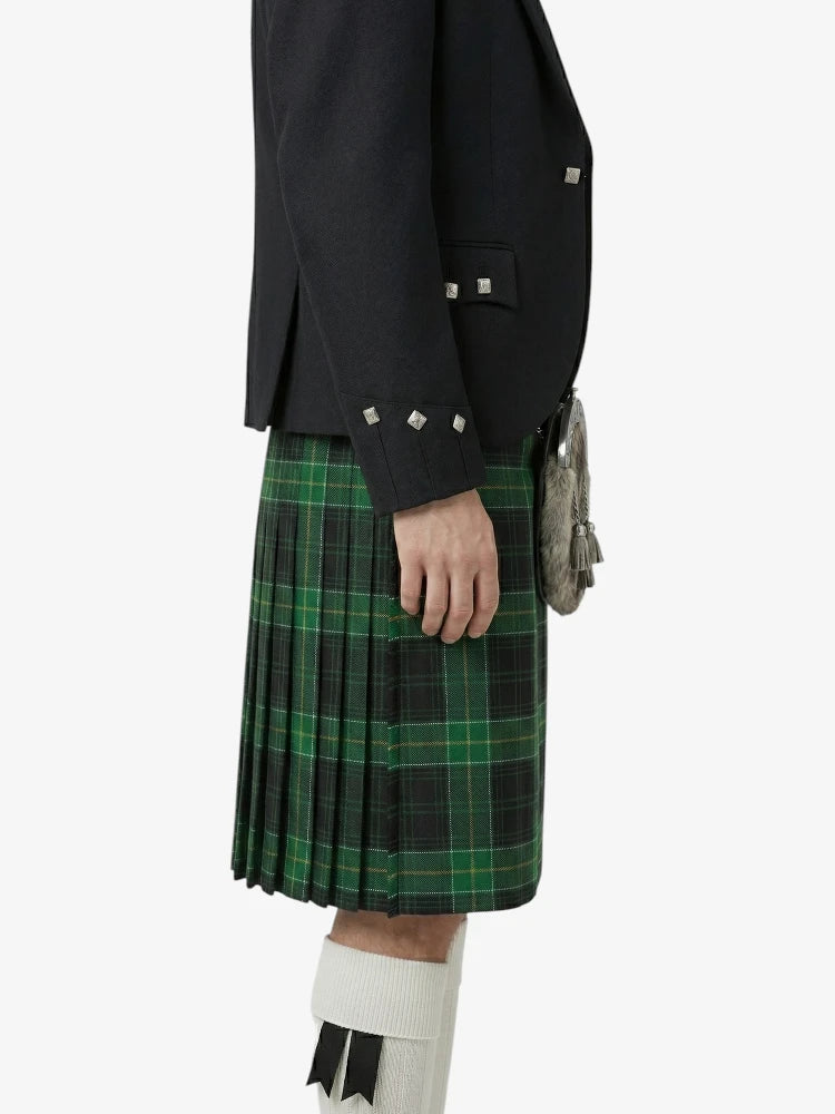 Person wearing a black jacket and green plaid kilt on a white background