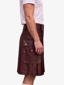 A side view of a person wearing a dark burgundy faux-leather kilt with silver snap buttons and flap pockets, paired with a white t-shirt, against a plain white background.