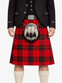 Person wearing a red tartan kilt with a black jacket on a white background