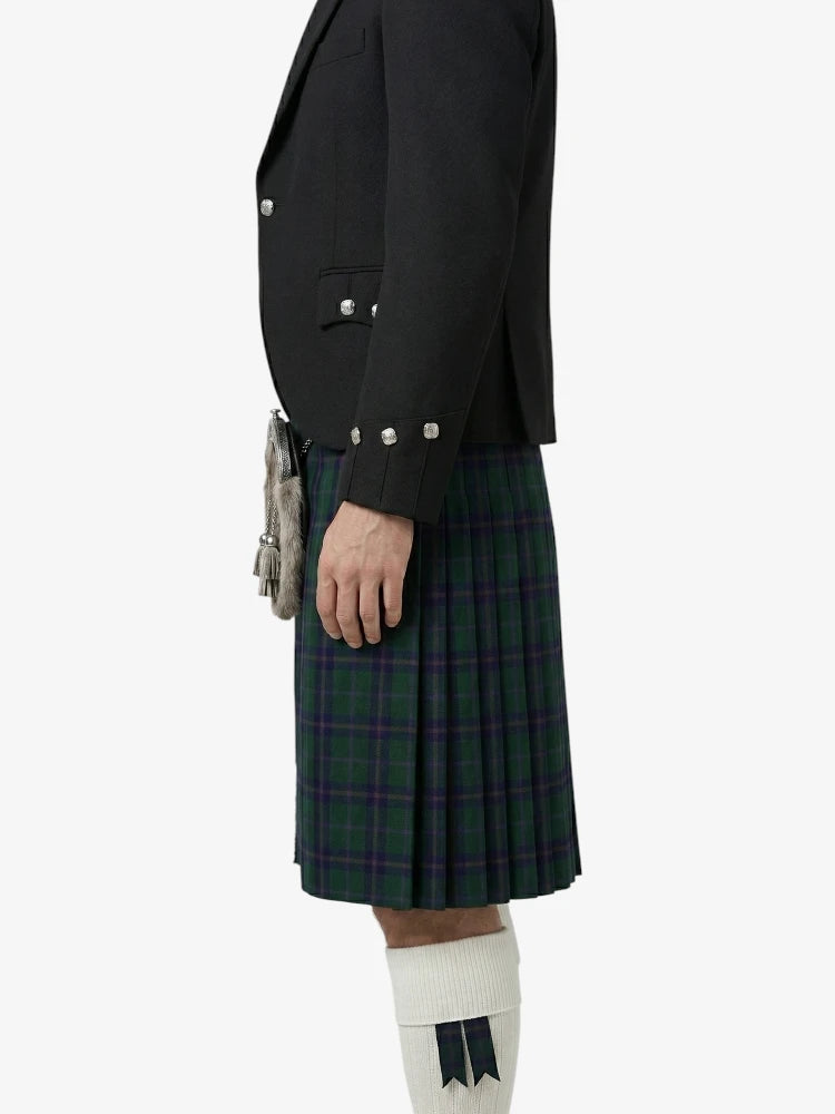 Person wearing a black jacket and green plaid kilt on a white background