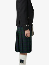 Person wearing a black jacket and green plaid kilt on a white background