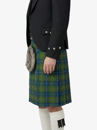 Person wearing a black jacket and green plaid kilt on a white background