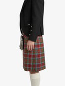 Person wearing a black blazer and red plaid kilt on a white background