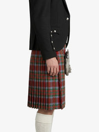 Person wearing a black blazer and red plaid kilt on a white background