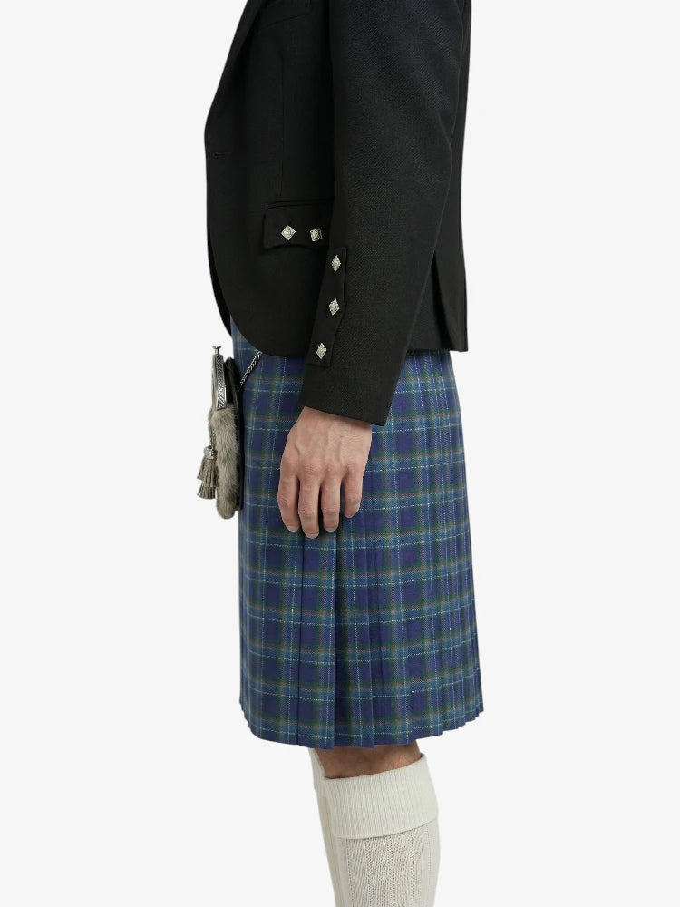 Person wearing a black blazer and blue plaid kilt on a white background