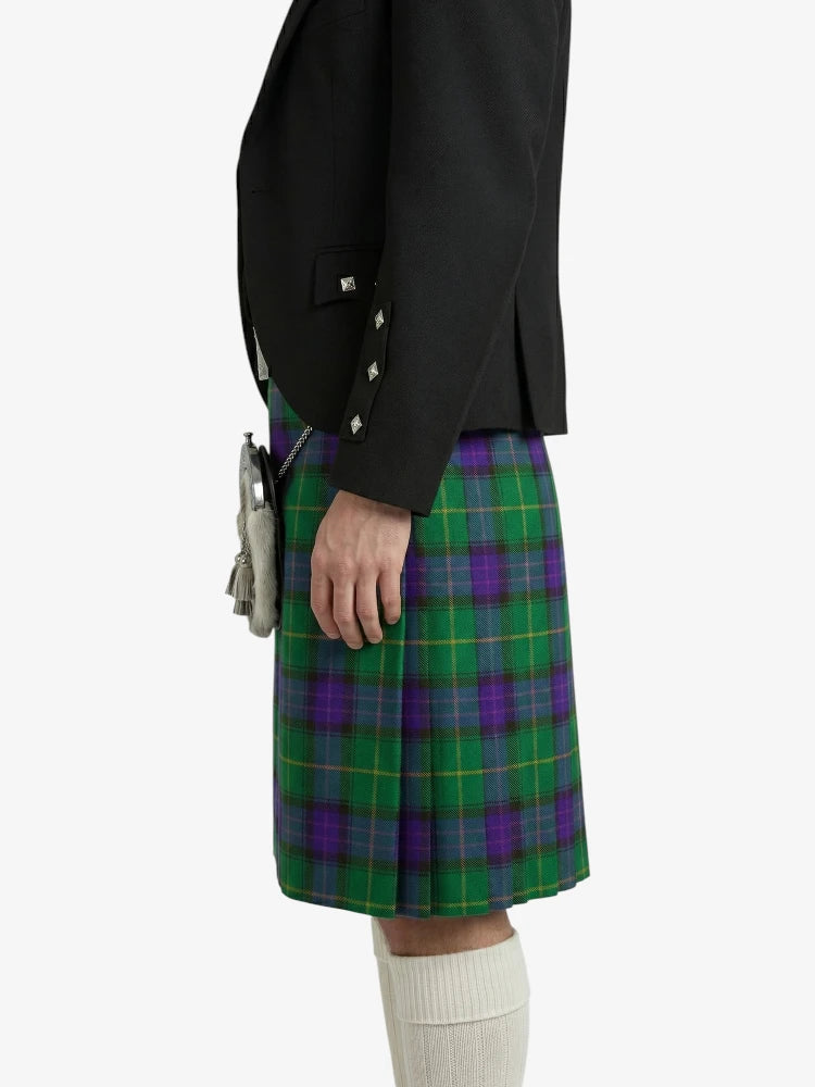Person wearing a black jacket and green plaid kilt on a white background