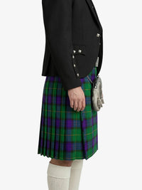 Person wearing a black jacket and green plaid kilt on a white background
