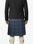 Person wearing a black coat and blue plaid kilt on a white background