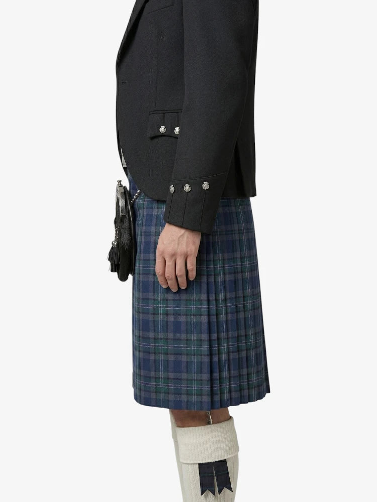 Person wearing a black blazer and blue plaid kilt on a white background