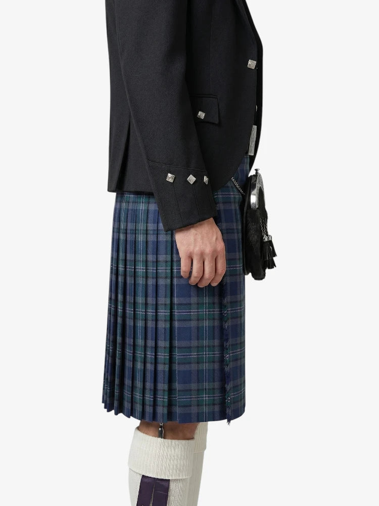 Person wearing a dark jacket and plaid kilt on a white background