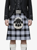 Person wearing a traditional Scottish kilt with a sporran on a white background