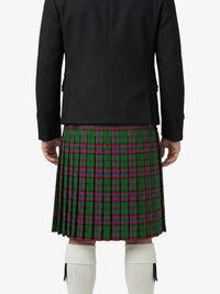 Person wearing a black jacket and green plaid kilt on a white background