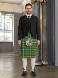Man wearing a traditional Scottish kilt in a room with a large mirror.