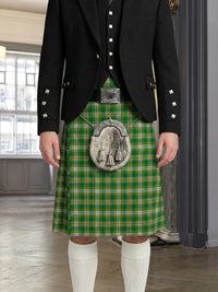 Person wearing a green plaid kilt with a decorative buckle in an indoor setting.