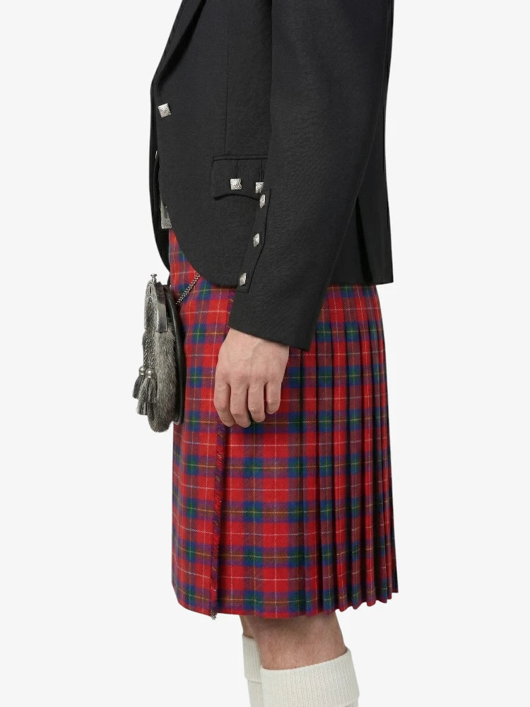 Person wearing a black blazer and red plaid kilt on a white background
