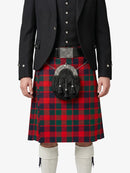 Person wearing a red and green plaid kilt with a black jacket on a white background