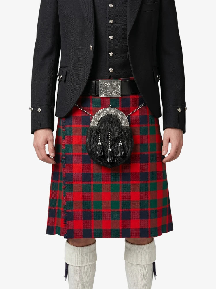 Person wearing a red and green plaid kilt with a black jacket on a white background