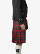 Person wearing a black jacket and red plaid kilt on a white background