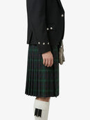 Person wearing a black jacket and green plaid kilt on a white background