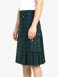 Person wearing a green and navy plaid kilt on a white background