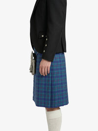 Person wearing a black blazer and blue plaid kilt on a white background