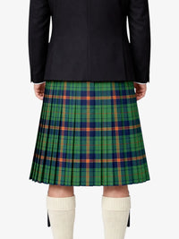 Person wearing a black jacket and green plaid kilt on a white background