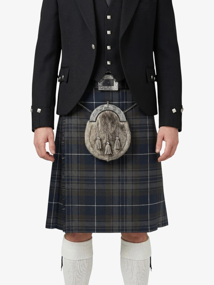Person wearing a traditional Scottish kilt with a jacket on a white background