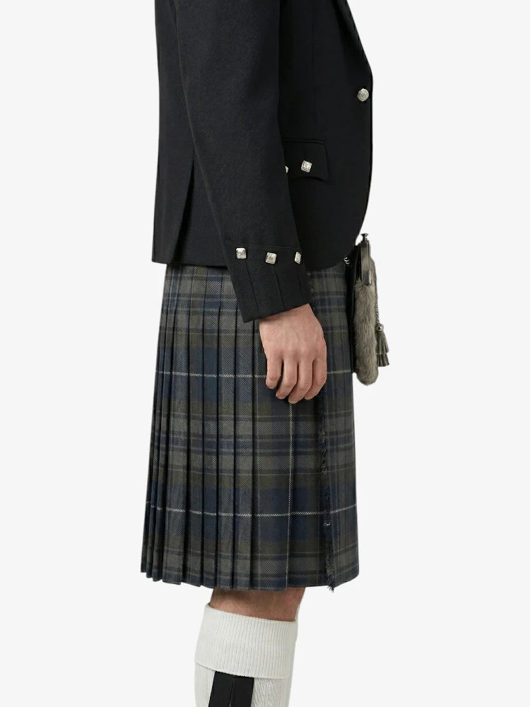 Person wearing a black jacket and plaid kilt on a white background