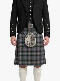 Person wearing a traditional Scottish kilt with a jacket on a white background