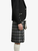 Person wearing a black blazer and plaid kilt on a white background