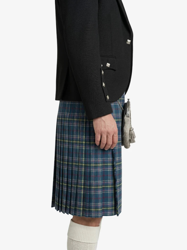 Person wearing a black blazer and blue plaid kilt on a white background