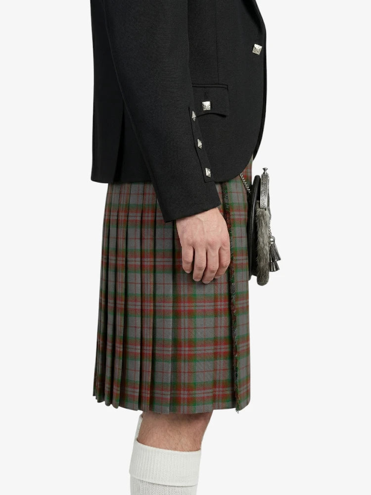 Person wearing a black jacket and plaid kilt on a white background