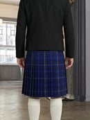 Person wearing a black jacket and blue plaid skirt indoors.