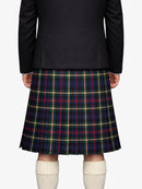 Person wearing a black blazer and plaid kilt on a white background