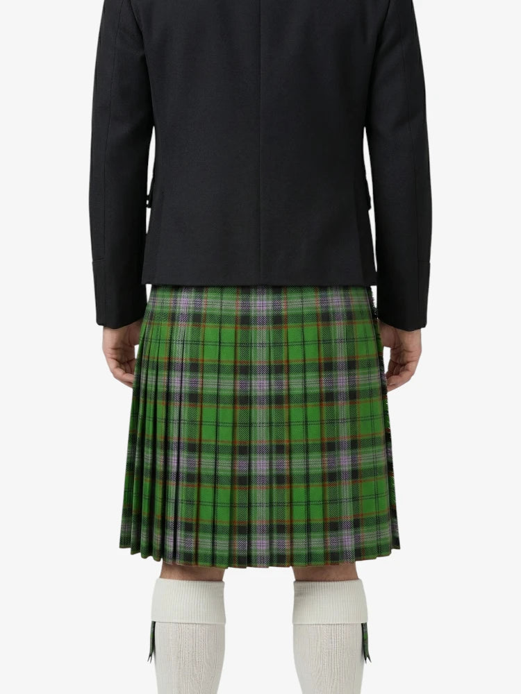 Person wearing a black jacket and green plaid kilt on a white background