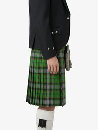 Person wearing a black jacket and green plaid kilt on a white background