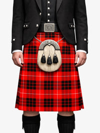 Person wearing a red tartan kilt with a black jacket on a white background