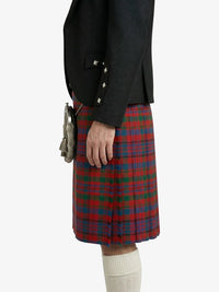Person wearing a black jacket and red plaid kilt on a white background