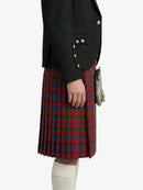 Person wearing a black jacket and red plaid kilt on a white background