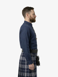 Man wearing a dark blue shirt and plaid kilt on a white background